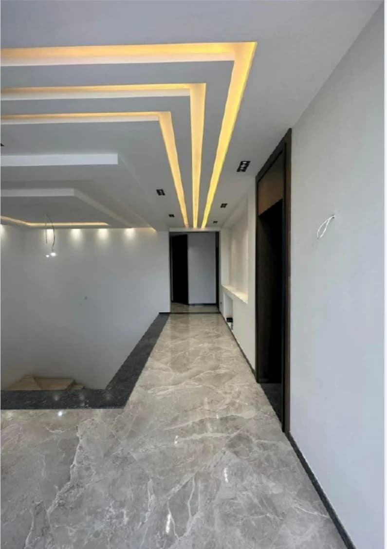 Couloir avec faux plafond géométrique éclairé